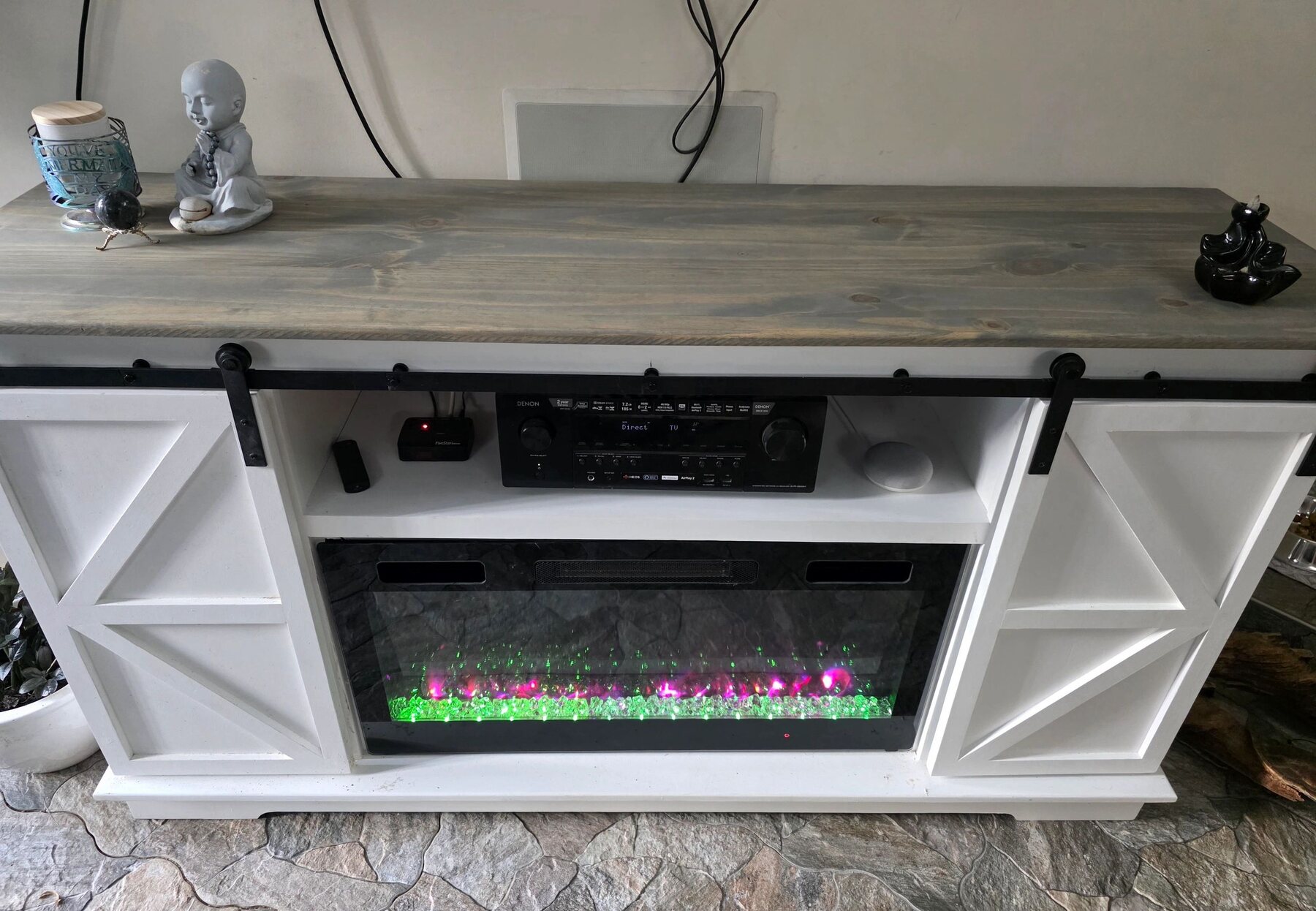 White 48-inch entertainment center with gray wood top, sliding barn doors and electric fireplace